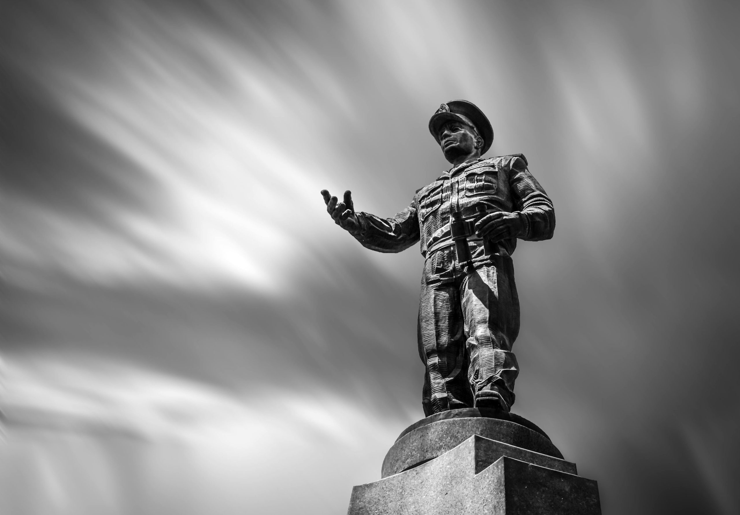 Black and white image of a prominent military statue with dramatic sky in Cairo, Egypt.